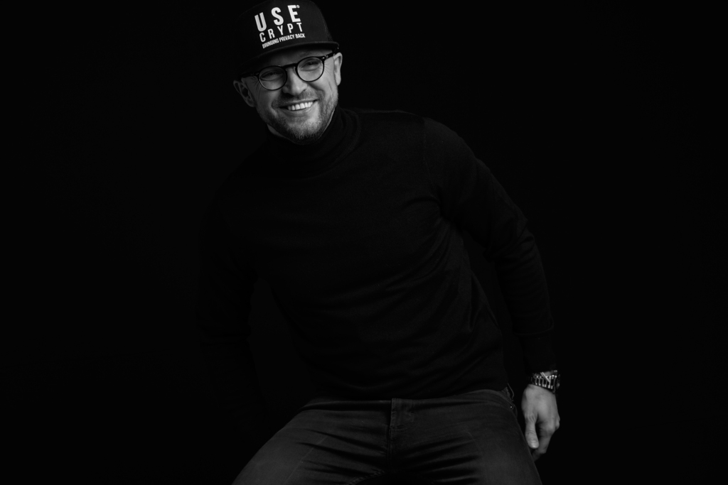 Pawel Makowski poses in UseCrypt Nation cap with glasses on and smiling
